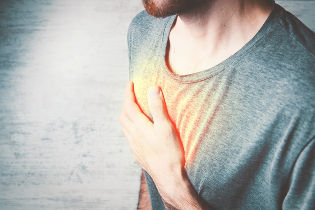 a man holding his chest with his hands